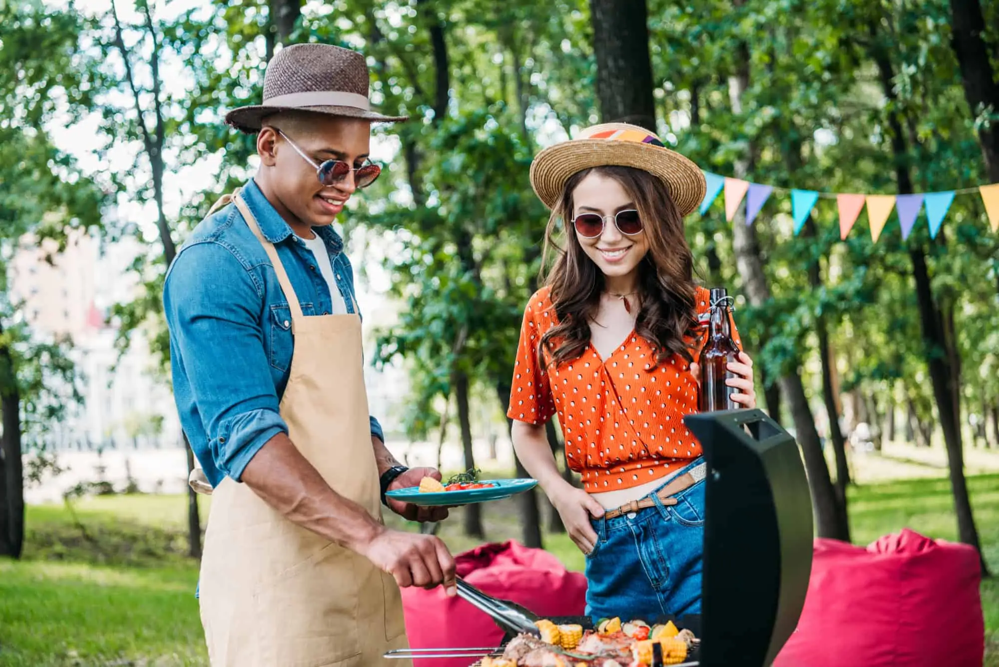 Happy smiling couple grilling in a park thinking about being a business owner as a chef