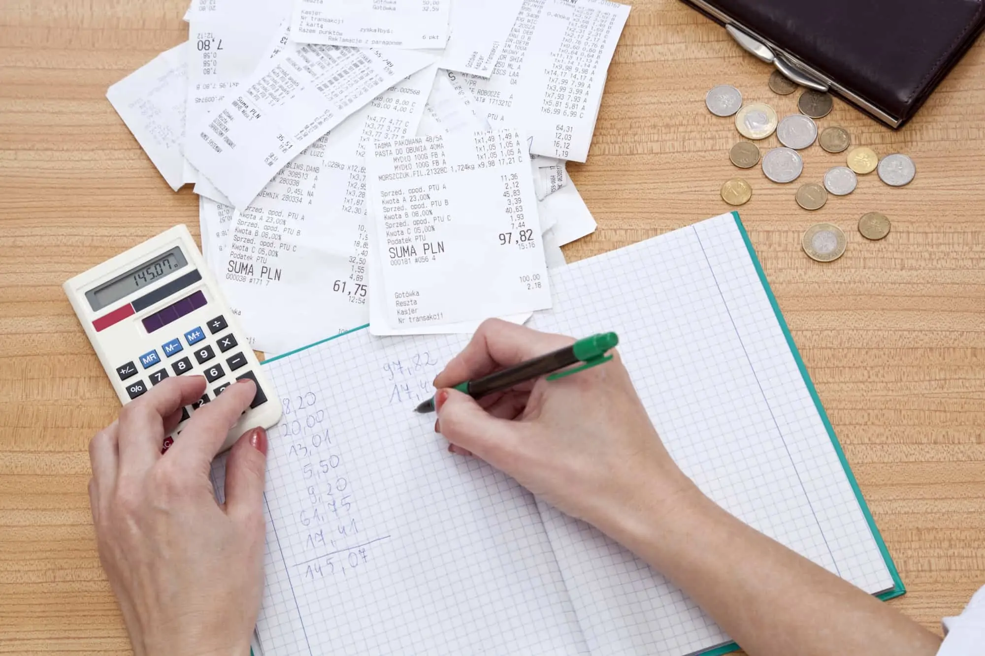 Woman calculating receipts to total all of the day's business expenses for recording.