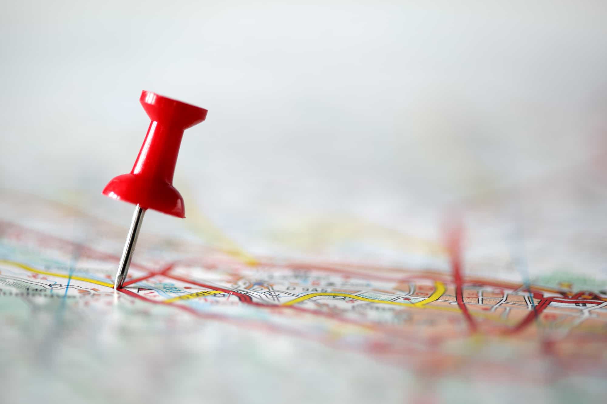 Red pushpin showing the location of a destination point on a map for naming a business
